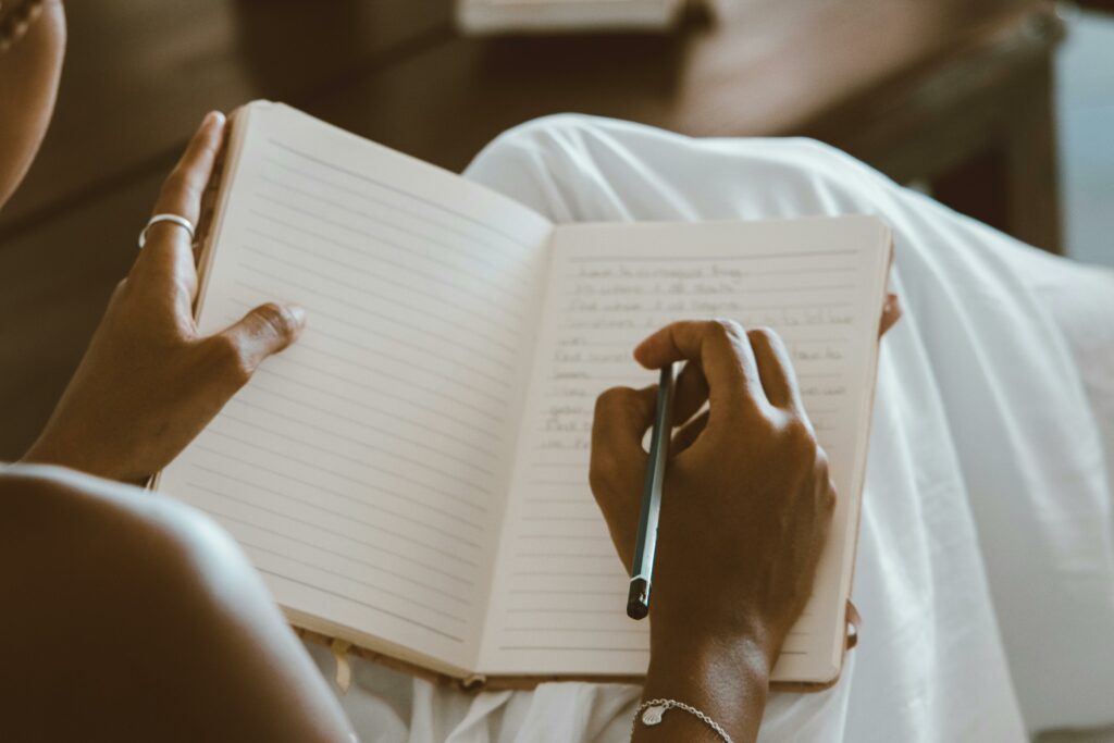 mujer-de-piel-morena-escribiendo-en-un-diario-de-gratitud